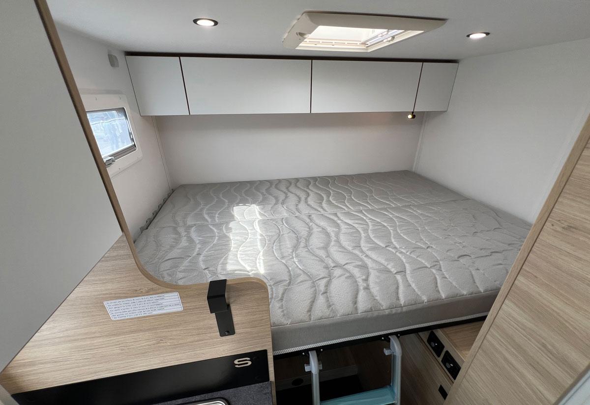 Chausson S614. Sous le lit dont le sommier peut se relever par moitié, des rangements côté cellule ou une soute pleine hauteur à l'arrière.