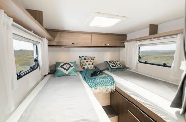 CARADO Van V337 - Les deux lits d'au moins 195 cm de long sont réunis en tête par une extension de matelas. L'accès simplifié se fait par le centre.