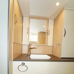 Façon dressing, l'arrière du camping-car offre un large panel de solutions de rangements : penderie avec tringle télescopique, tiroirs, placards avec étagères.