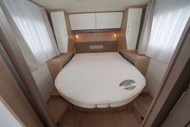 RAPIDO M 96 : le sommier rétractable libère le passage dans la journée. A l'arrière des penderies, des espaces de rangement avec prises USB et 12 V. Le matelas prend ses aises (160 x 198 cm).