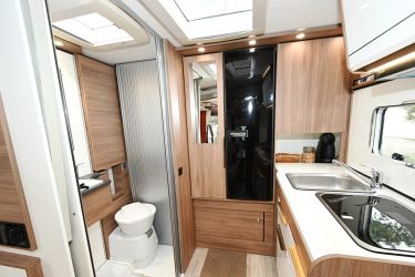 Salle d'eau et cuisine sur les côtés, grande penderie et frigo 138 L au fond, se partagent astucieusement l'espace arrière du profilé