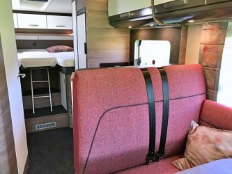 La séparation entre la banquette face route et la cuisine en L, sert de logement au téléviseur télescopique en option