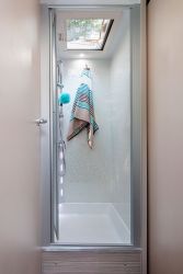 Le bac à douche en polyester haute résistance affiche de belles dimensions (71 x 71 cm). Un lanterneau assure l'aération.