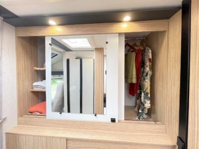 Un grand miroir est installé sur la porte du dressing.